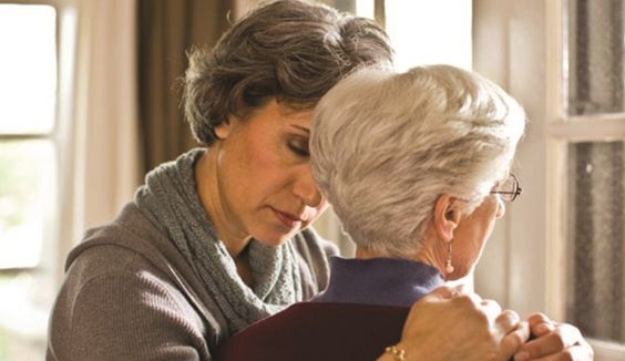 woman holding parent with stressed experession